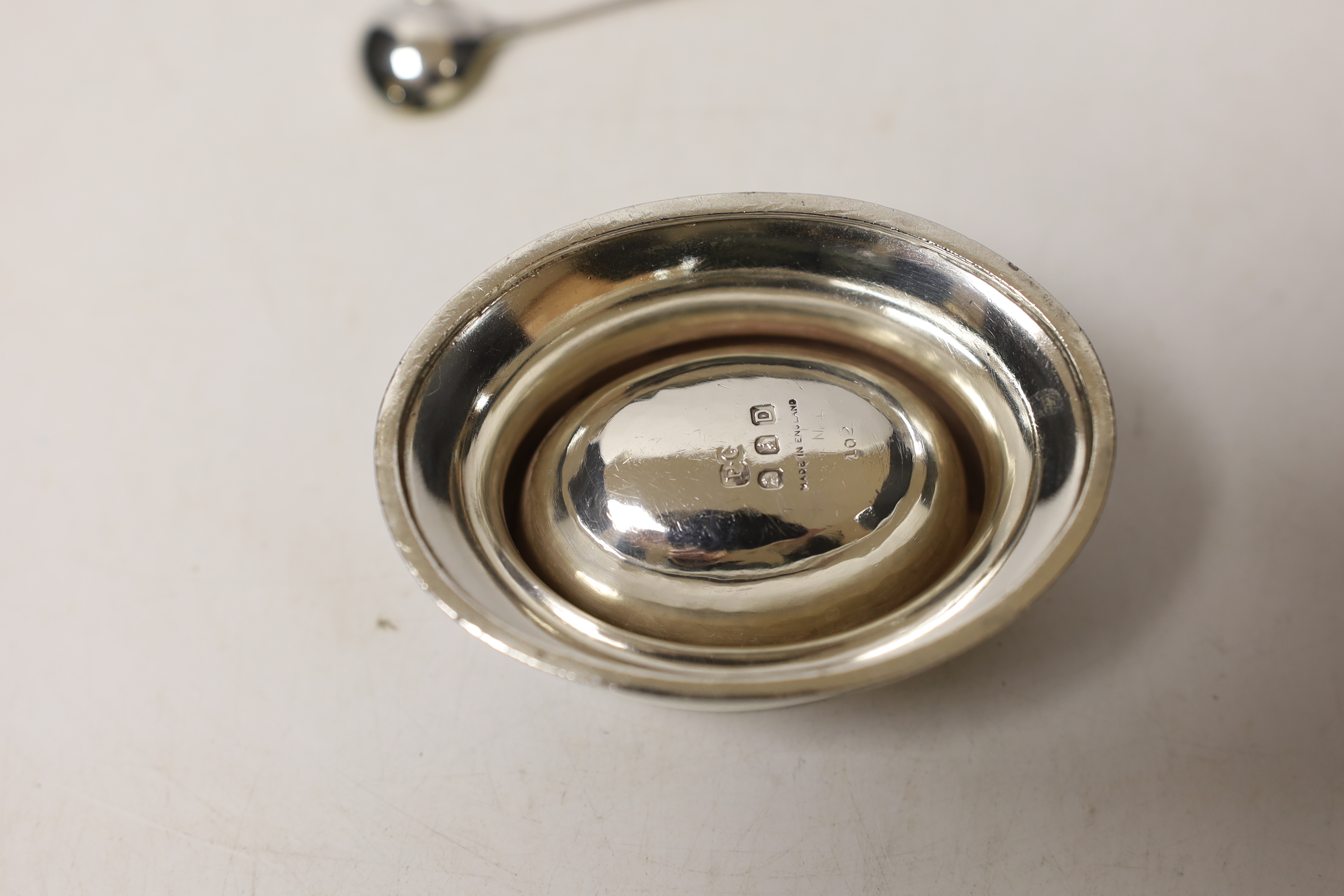 A boxed pair of George VI Britannia standard silver oval salts, Peter Guile Ltd, London, 1939, 8cm and a pair of late associated silver spoons.